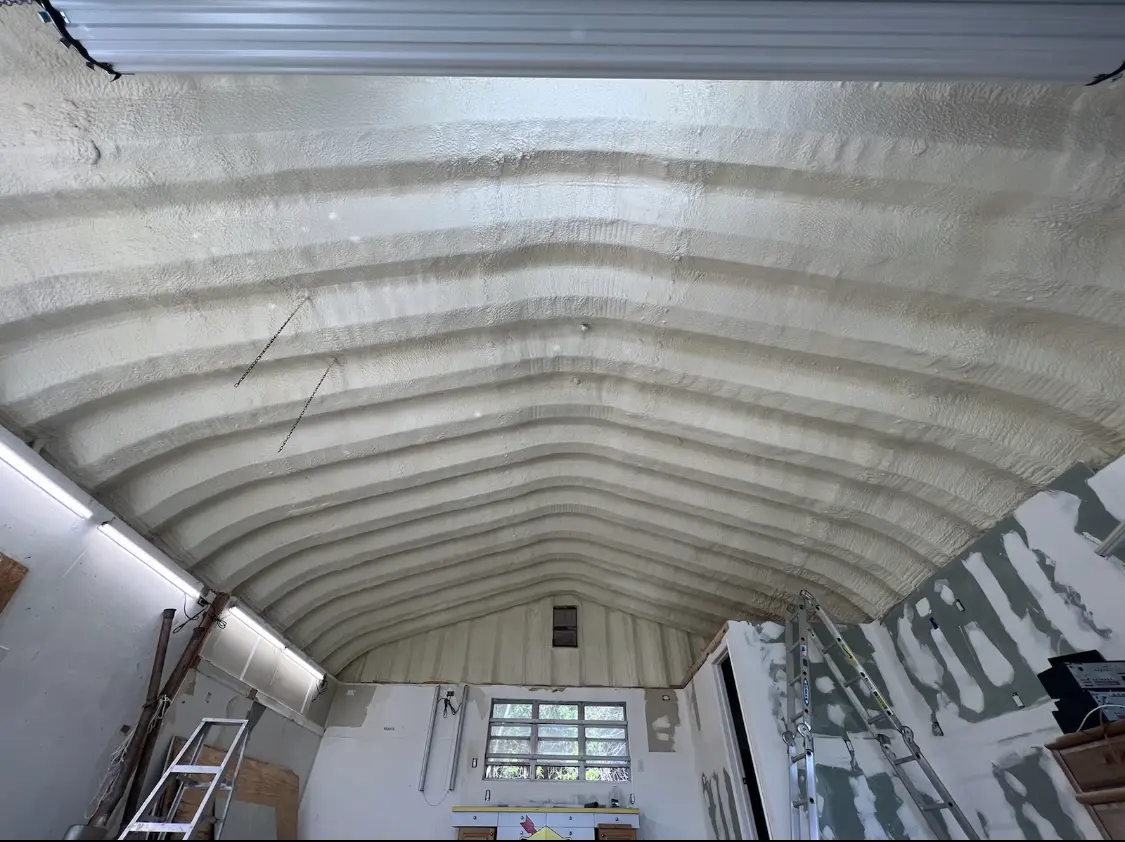 Spray polyurethane foam applied to the underside of a metal roof deck in Comstock